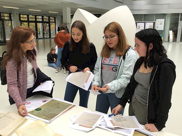 Schülerinnen studieren mittelalterliche Texte