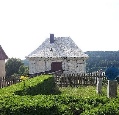 Weißes Gartenhaus im Kloster Lorch. Hintergrund Wald.