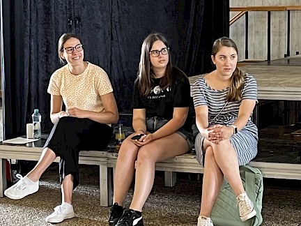 Drei Studienbotschafterinnen sitzen in der Aula